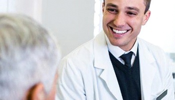 A dentist talking with a patient about the process of receiving dental implants