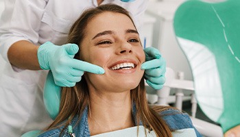 Patient smiling at reflection in handheld mirror