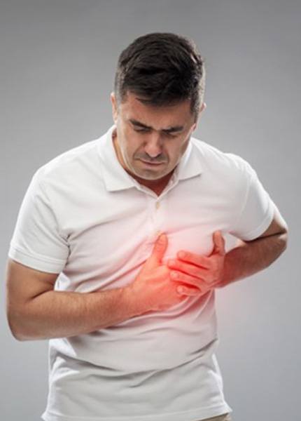 Man in white polo shirt suffering heart problems