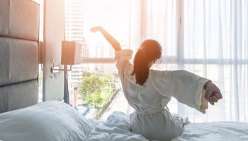 Woman waking up refreshed after good night’s sleep