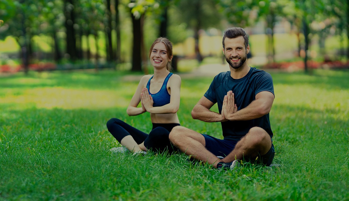 Man and woman doing yoga in a park