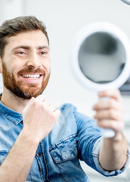 Male dental patient checking smile after cosmetic dental bonding in South Portland, ME