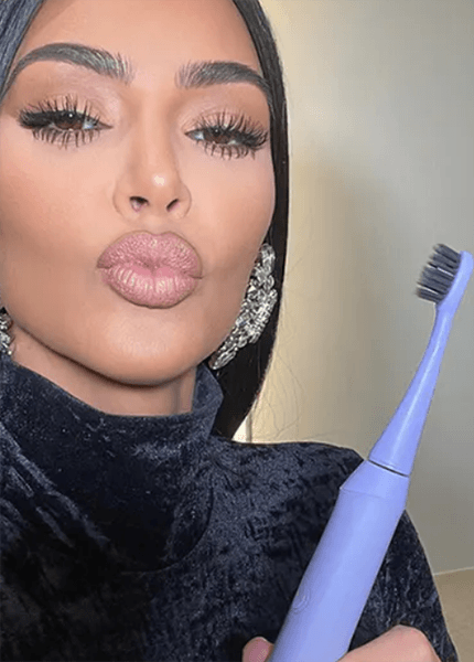 Woman in black turtleneck holding her Burst toothbrush