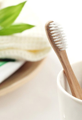 Bamboo toothbrushes next to a tube of toothpaste