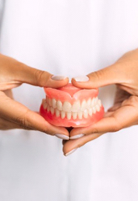 Dentist holding a set of dentures