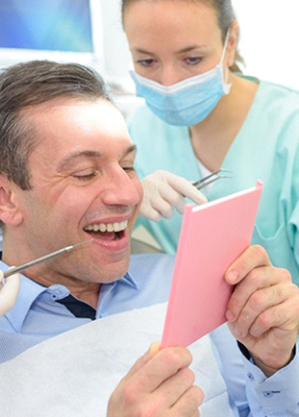 Man admiring dental bridge in South Portland