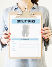 Woman holding clipboard with dental insurance information