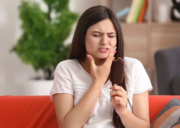 Woman in need of emergency dentistry holding jaw in pain