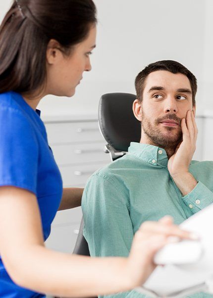 Man holding jaw during emergency dentistry visit