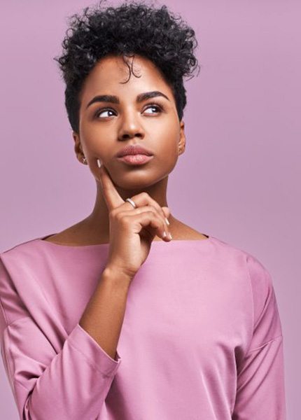 Woman tapping her chin in a questioning pose
