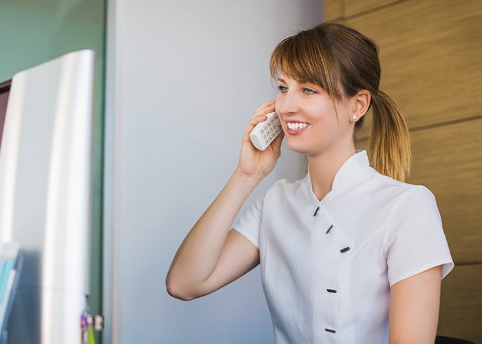 Smiling dental team member ansering the phone