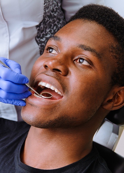 Man receiving dental checkup and teeth cleaning