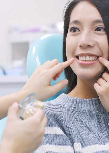 A woman pointing to her dental implant