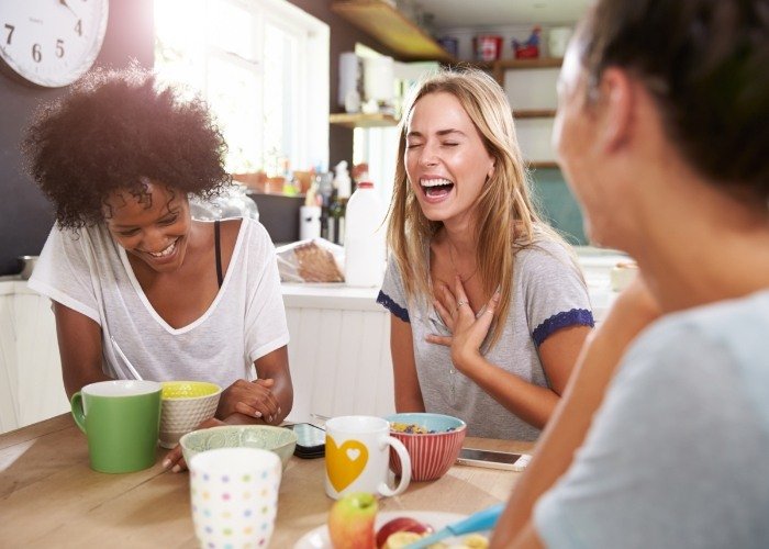 Woman with healthy smile thanks to dental services laughing with her friends