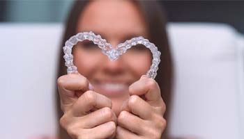 patient making a heart out of Sure Smile aligners