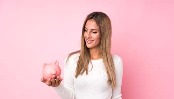 woman smiling and holding a piggy bank to make Sure Smile treatment affordable
