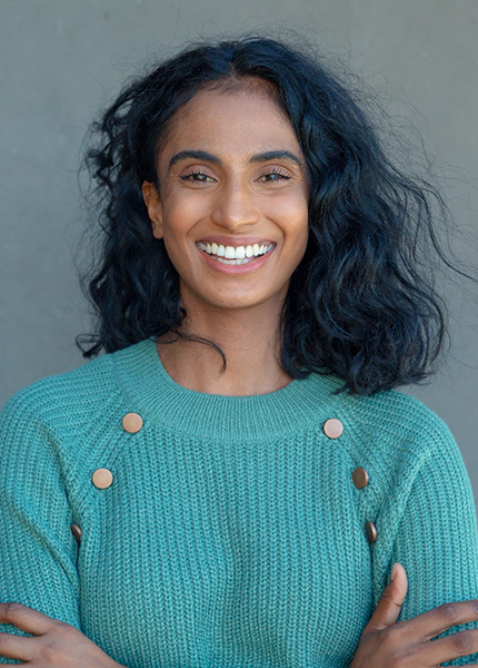 smiling person with their arms crossed