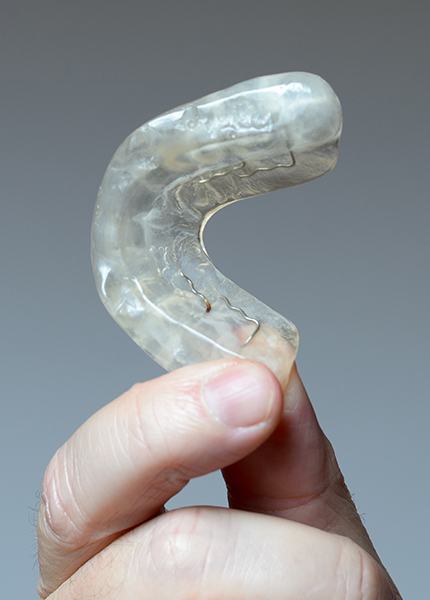 Hand holding a custom occlusal splint