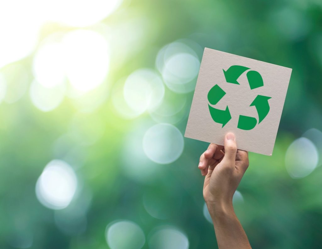 Patient holding up recycling sign on Earth Day