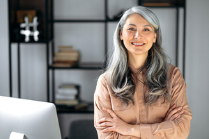 Woman standing in office and smiling