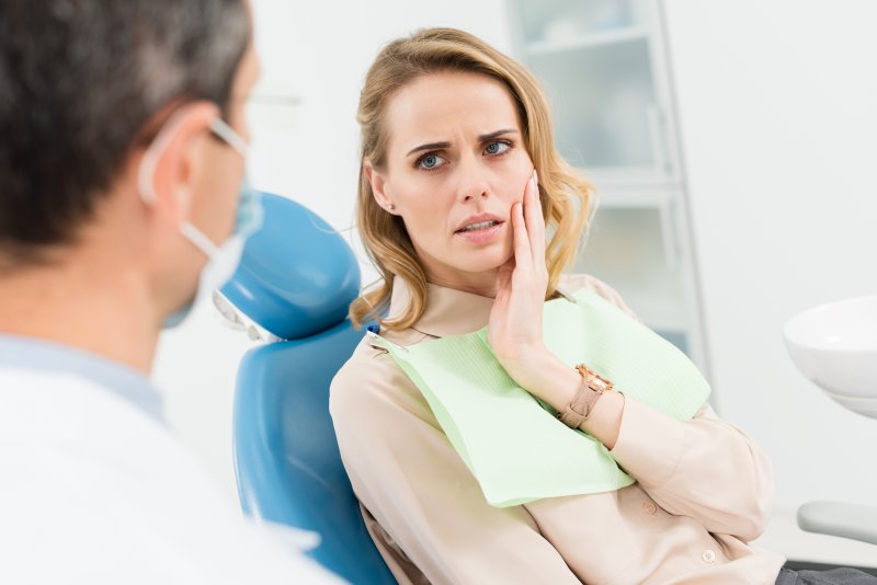 Patient holding their jaw due to dental emergencies