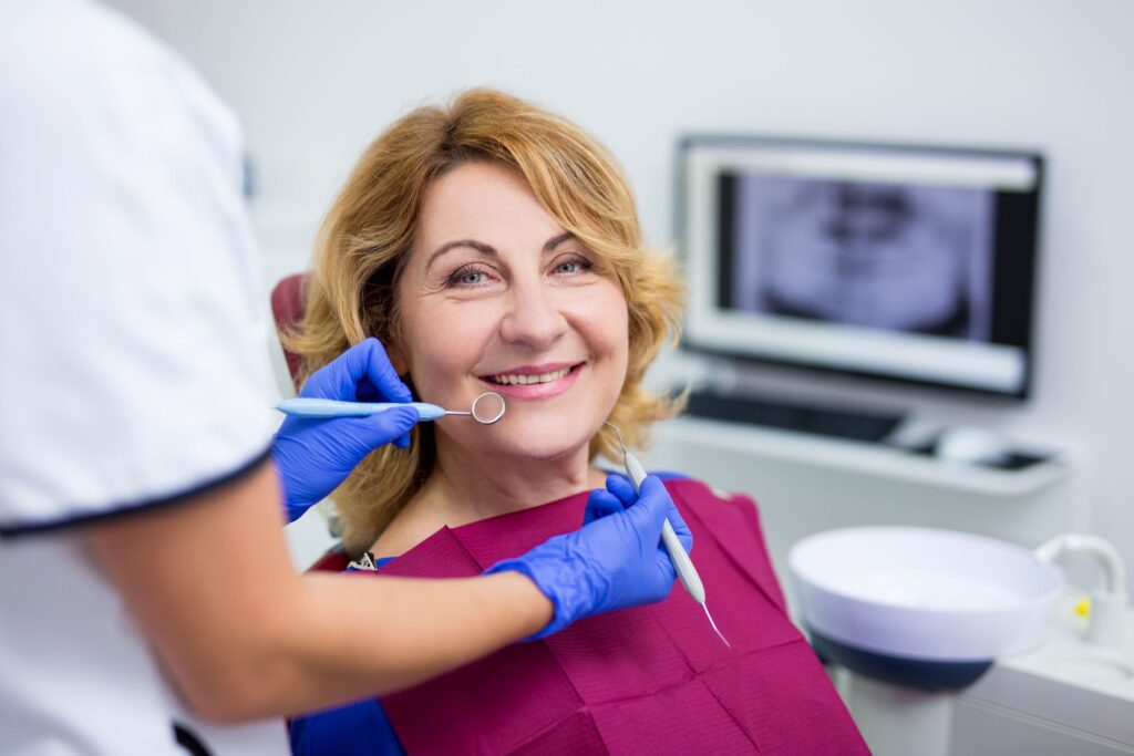 Woman with red bib in dental chair about to have exam