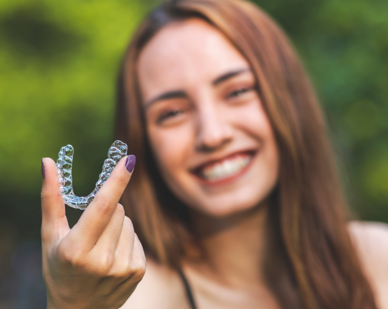 Woman holding clear aligner